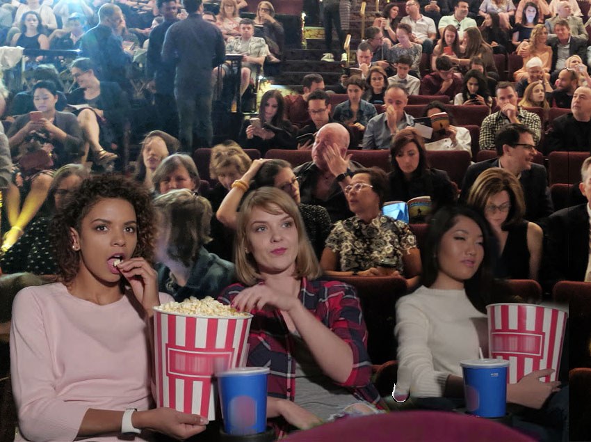 Broadway audience members eating popcorn